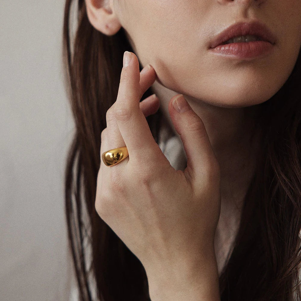 Side view of a lightweight, golden dome-shaped ring.