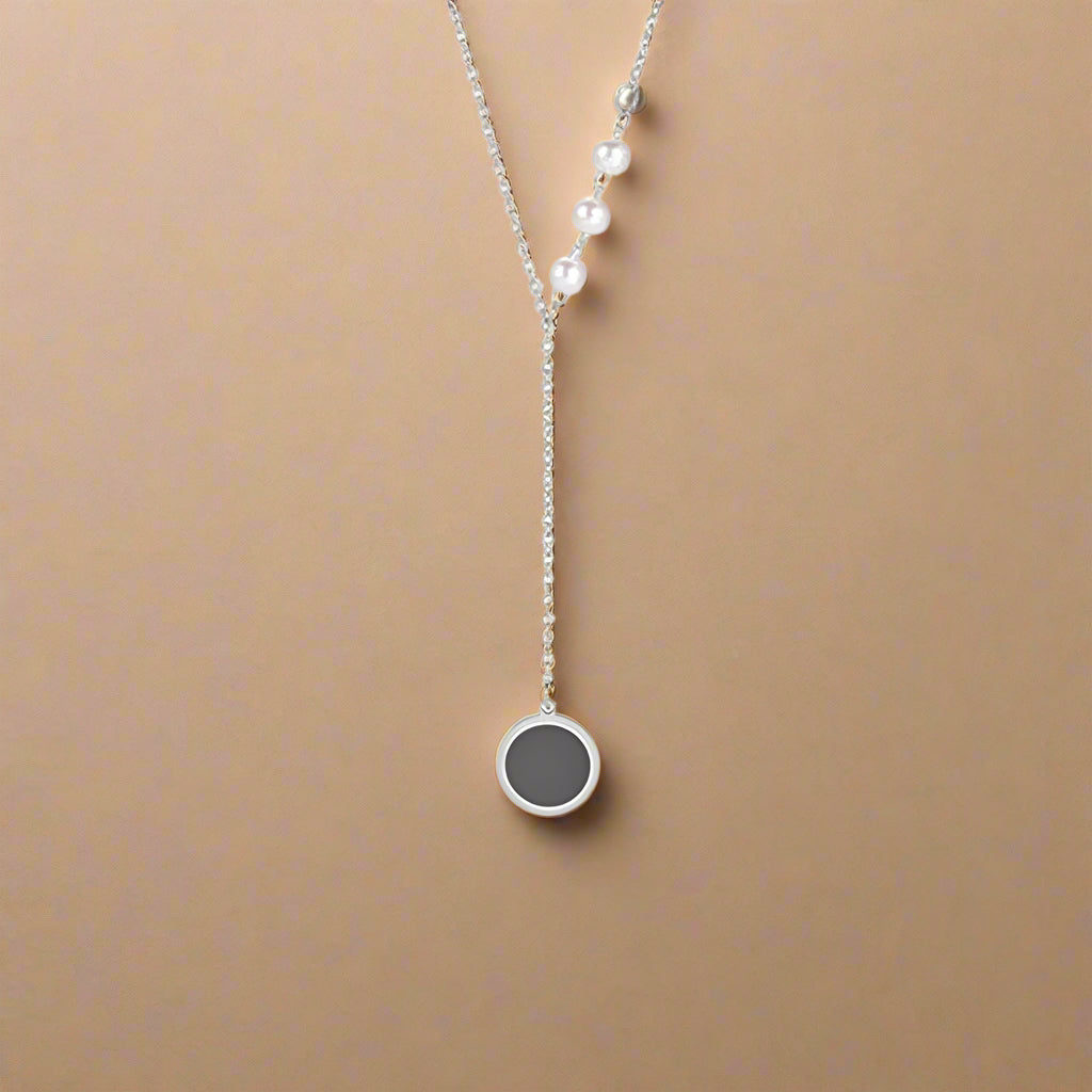 Silver minimalist necklace with pearl accents and black circle pendant
