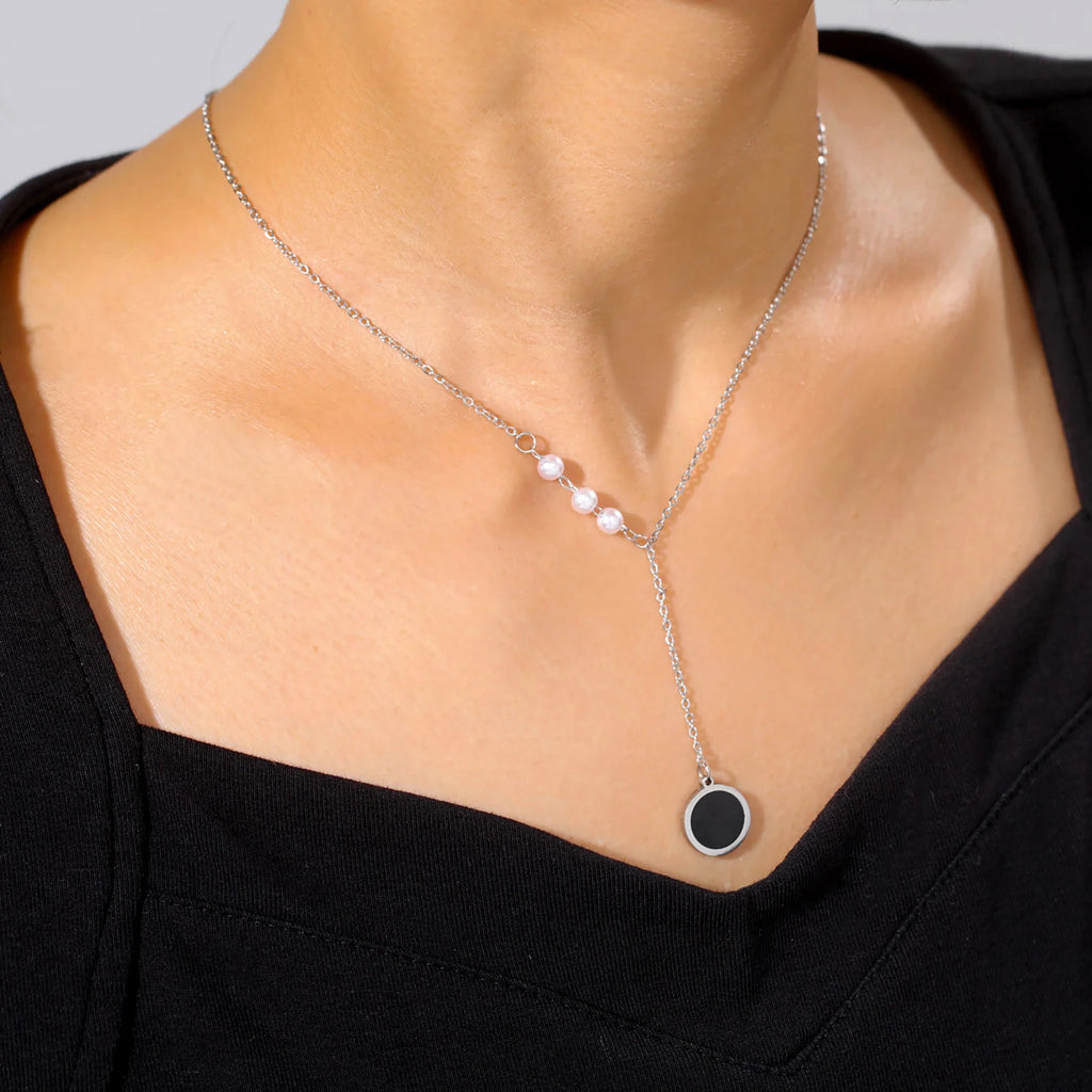 Silver minimalist necklace with pearl accents and black circle pendant