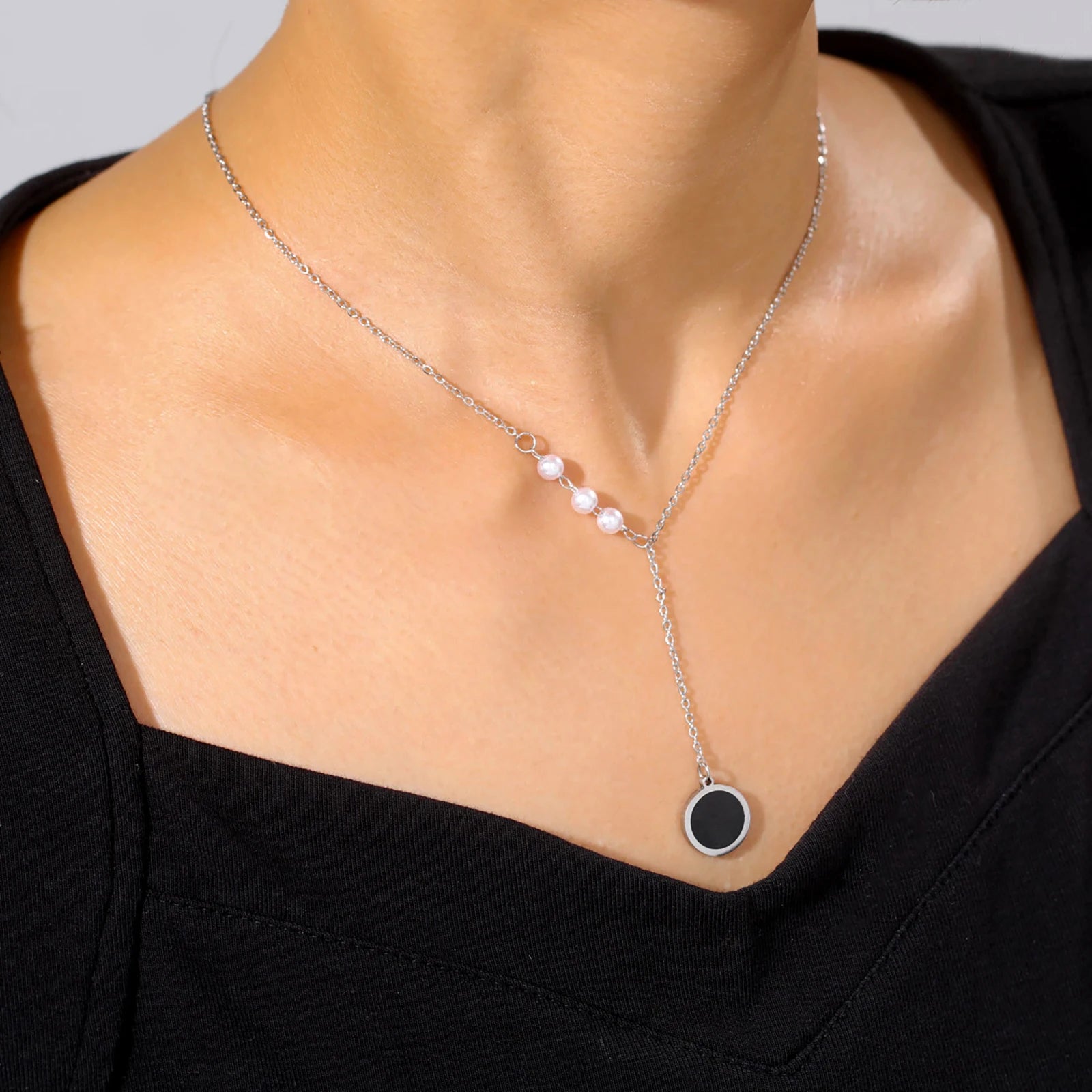 Silver minimalist necklace with pearl accents and black circle pendant