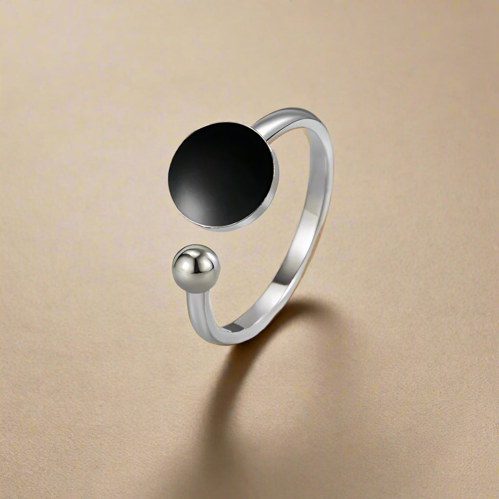 Close-up of black glazed stainless steel open ring on white background