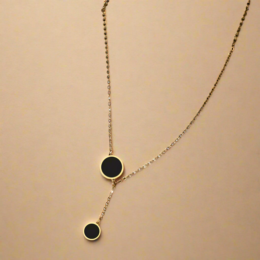 Minimalist black enamel circle pendant necklace in gold finish – flat lay
