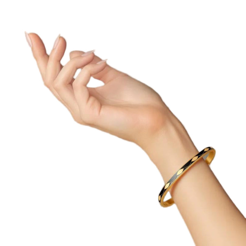 Hand wearing a gold bracelet on a plain background