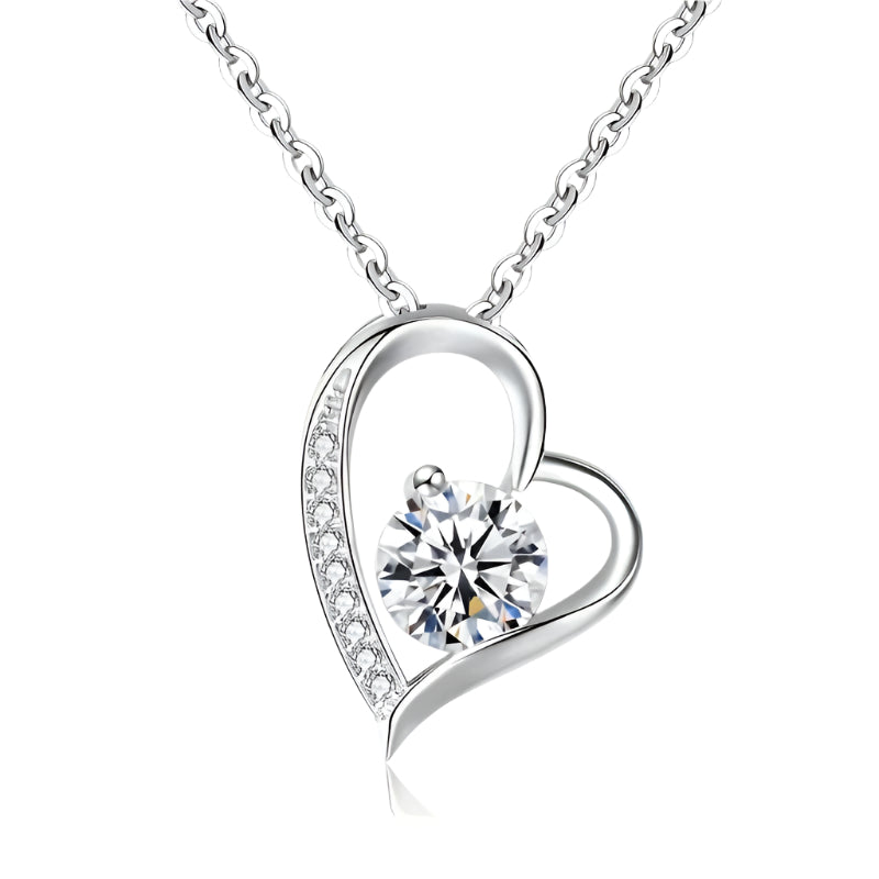 Heart-shaped silver necklace with a central gemstone on a white background