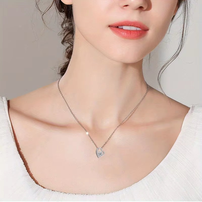 Necklace with a heart-shaped pendant worn by a model against a neutral background